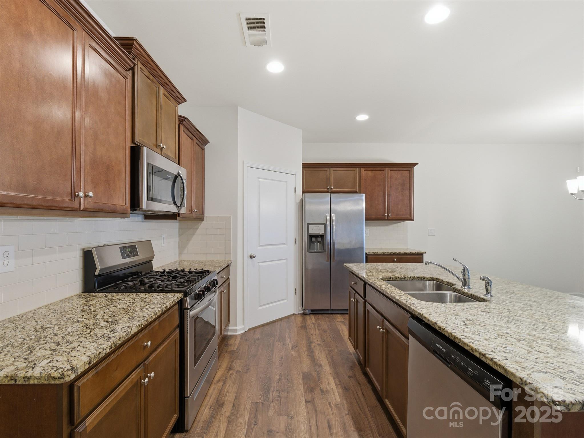 2212 Apple Glen Lane Charlotte, NC 28269 - Photo 7 of 32 a kitchen with stainless steel appliances granite countertop a stove a sink and a refrigerator