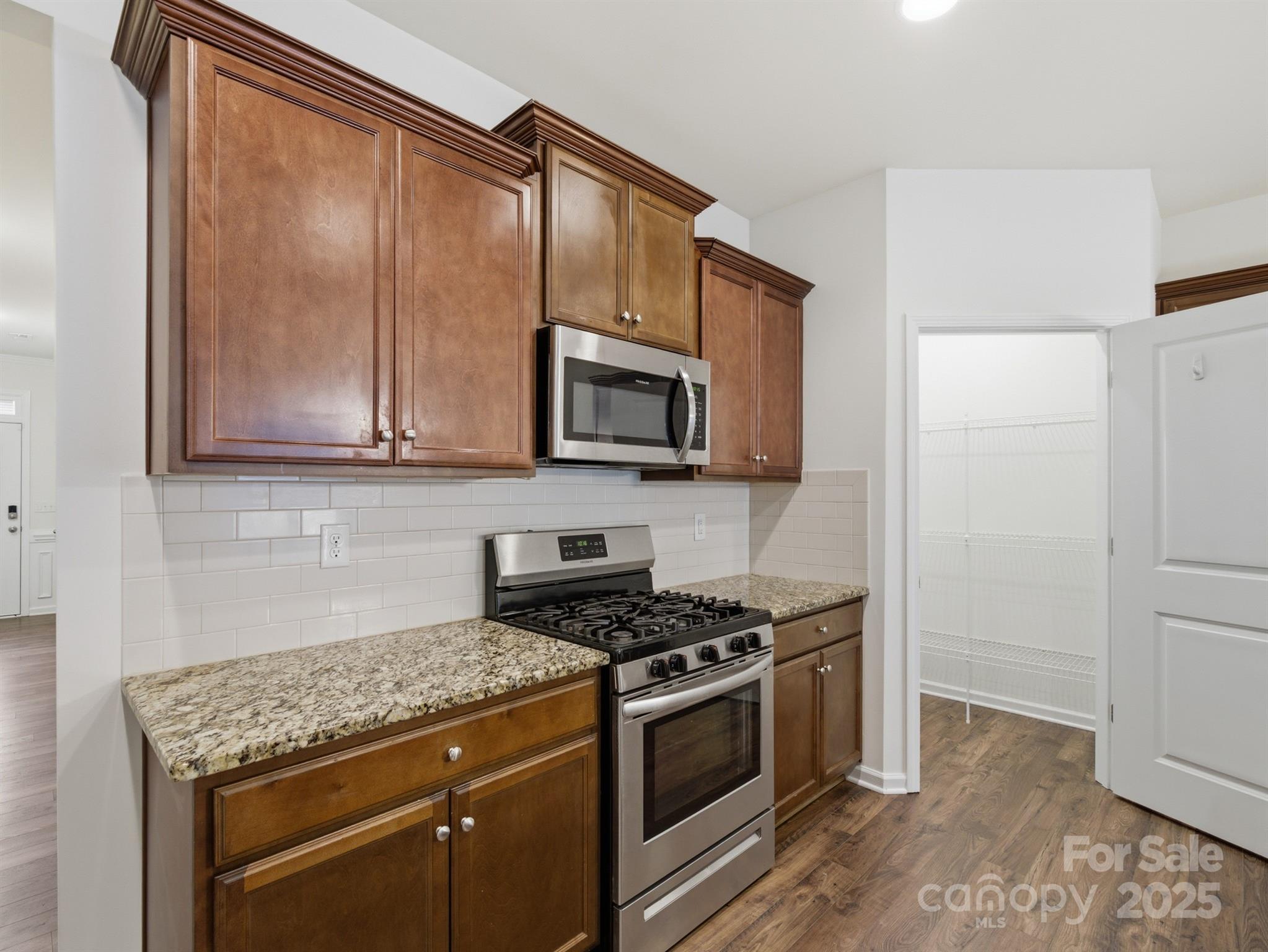 2212 Apple Glen Lane Charlotte, NC 28269 - Photo 8 of 32 a kitchen with stainless steel appliances granite countertop a stove microwave and sink