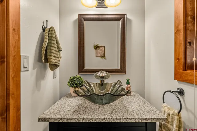 a bathroom with a granite countertop sink and a mirror