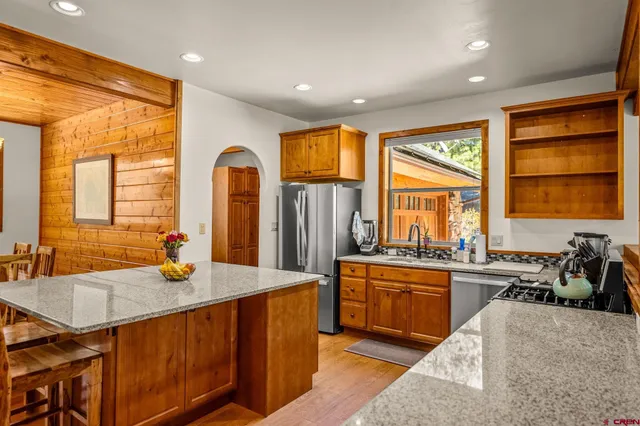 a kitchen with stainless steel appliances granite countertop sink stove top oven and cabinets