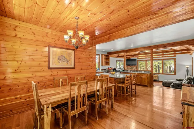 a view of a dining room with furniture a chandelier and wooden floor