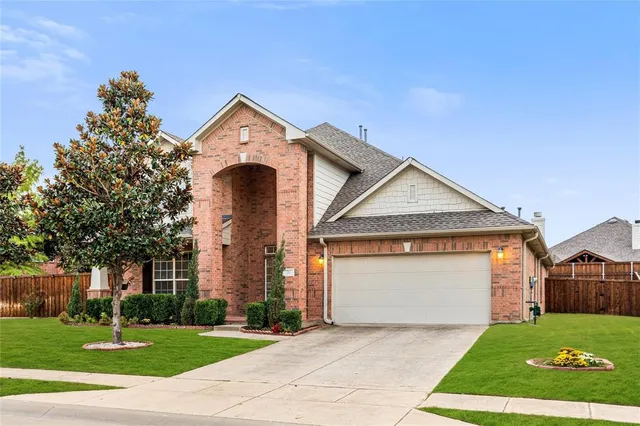 a view of a house with a yard and large tree