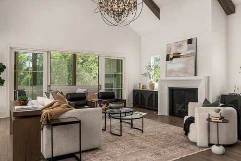 a living room with furniture a fireplace and a large window
