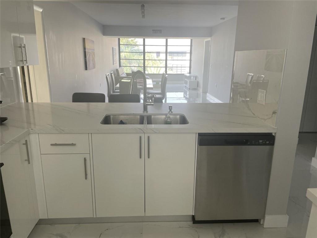 1721 Whitehall Drive, Unit 404 Davie, FL 33324 - Photo 1 of 16 a kitchen with stainless steel appliances white cabinets and a window
