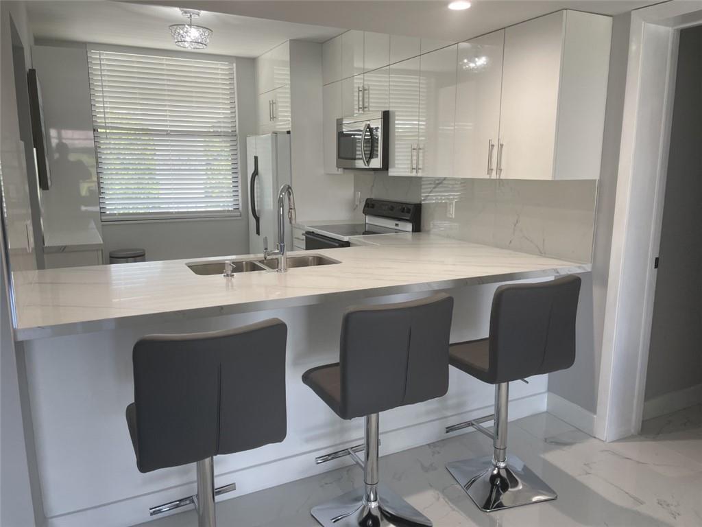 1721 Whitehall Drive, Unit 404 Davie, FL 33324 - Photo 2 of 16 a kitchen with a sink cabinets and window
