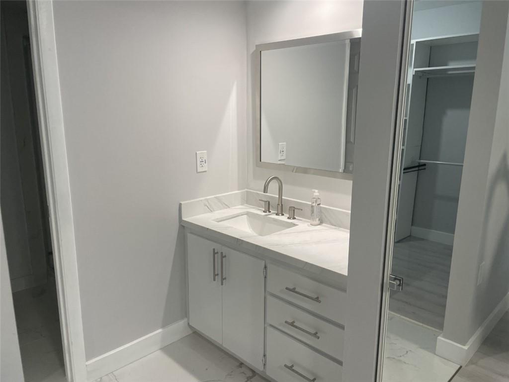 1721 Whitehall Drive, Unit 404 Davie, FL 33324 - Photo 8 of 16 a bathroom with a granite countertop sink and a mirror
