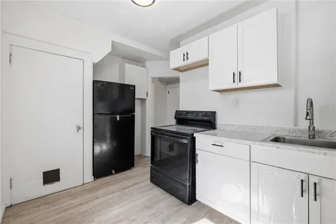 a kitchen with a refrigerator sink and cabinets