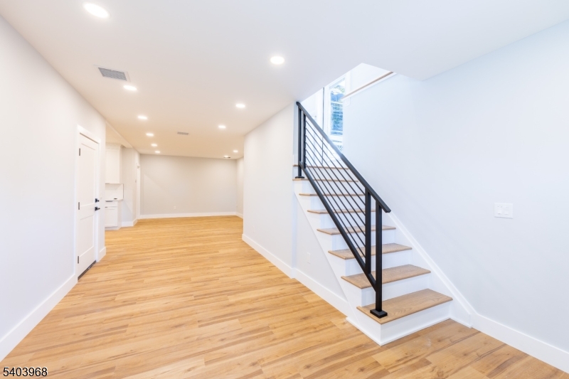 24 Bertrand Island Road Mount Arlington, NJ 07856 - Photo 12 of 44 a view of a hallway with wooden floor and staircase