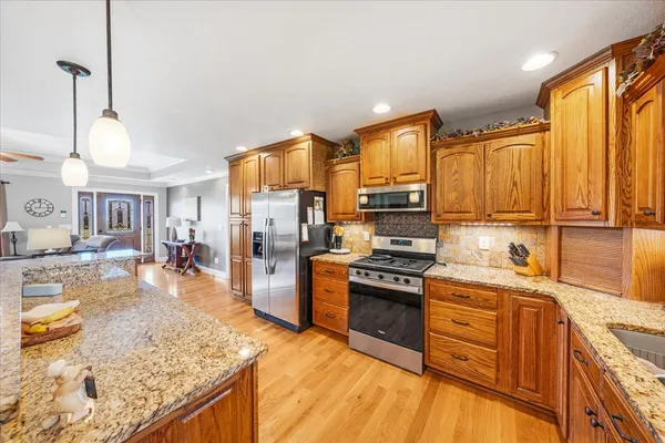 a kitchen with stainless steel appliances granite countertop a sink stove and refrigerator