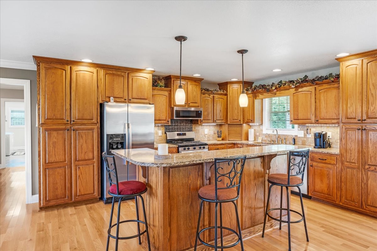 379 Hooper Road Winchester, TN 37398 - Photo 17 of 52 a kitchen with stainless steel appliances granite countertop a stove a refrigerator a sink dishwasher and white cabinets with wooden floor
