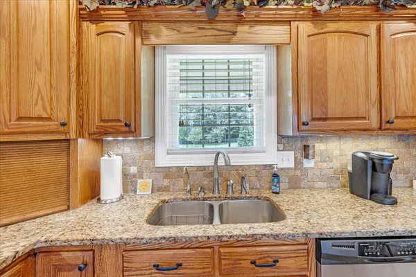 a kitchen with granite countertop cabinets sink and window