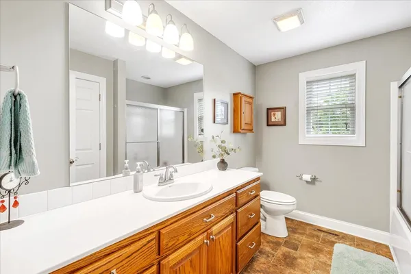 a bathroom with a sink a toilet and a large mirror