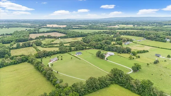 an aerial view of a residential houses with outdoor space and a lake view