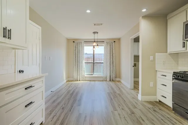 a dining room with furniture potted plants and wooden floor
