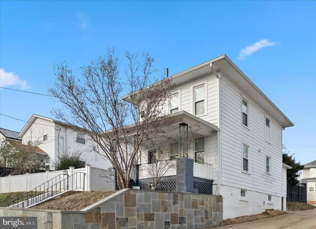 a front view of a house with a tree