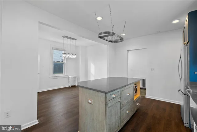 a kitchen that has a lot of cabinets and wooden floor