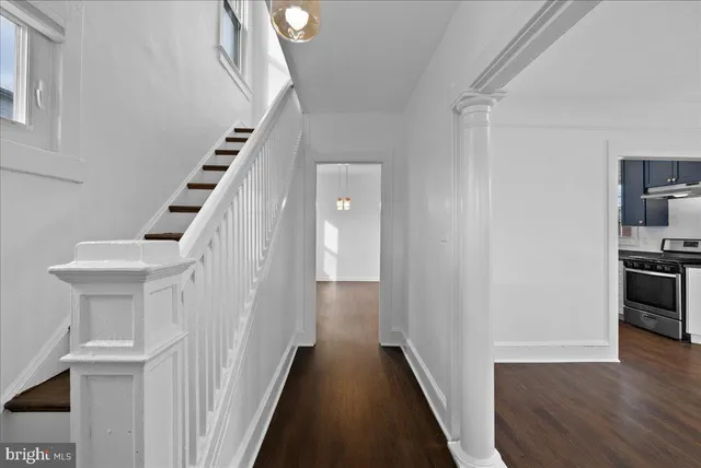 a view of a hallway with wooden floor and staircase