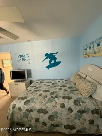 a bedroom with a bed and painting on the wall