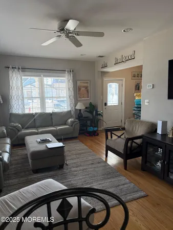 a living room with furniture and a wooden floor