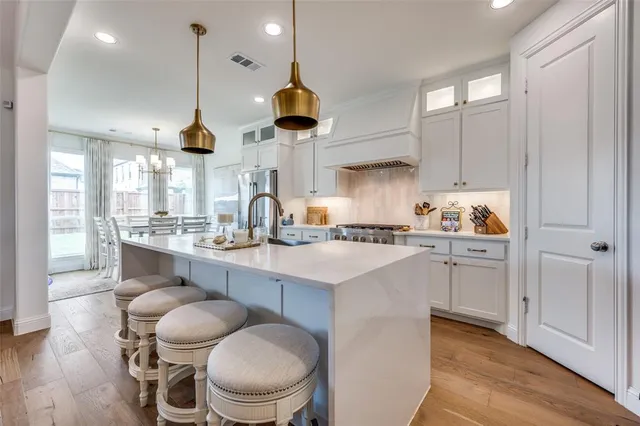 a kitchen with a sink cabinets and wooden floor