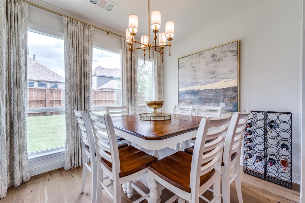 2390 Red Cedar Trail Prosper, TX 75078 - Photo 15 of 40 a dining room with wooden floor a chandelier a wooden table and chairs