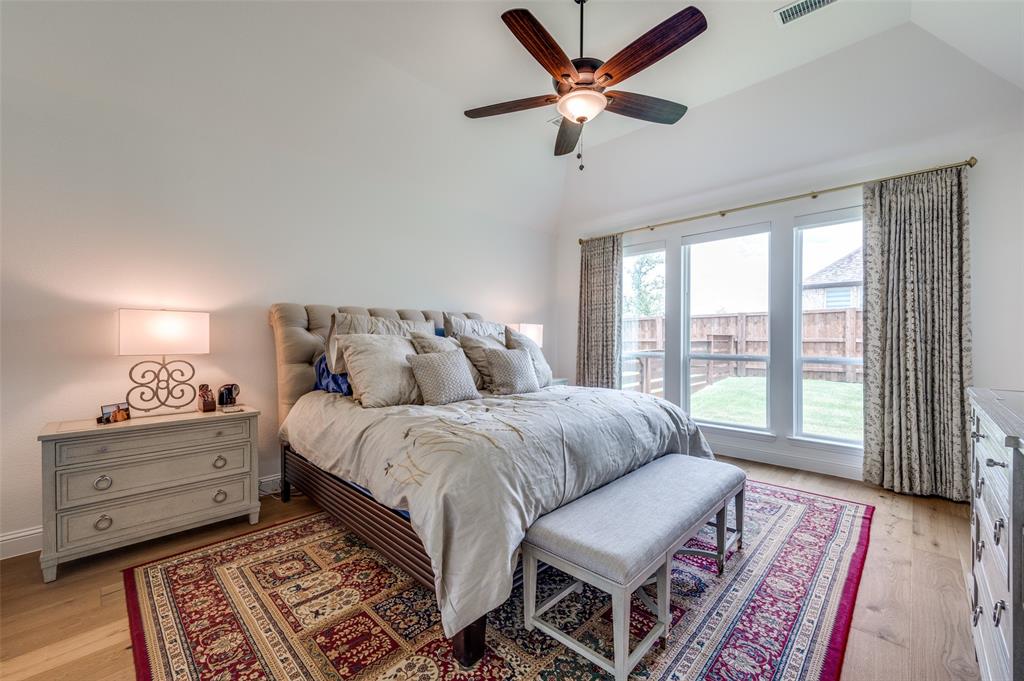2390 Red Cedar Trail Prosper, TX 75078 - Photo 22 of 40 a spacious bedroom with a bed and a chandelier