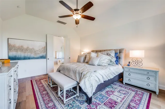 a bedroom with a bed a lamp and a bookshelf