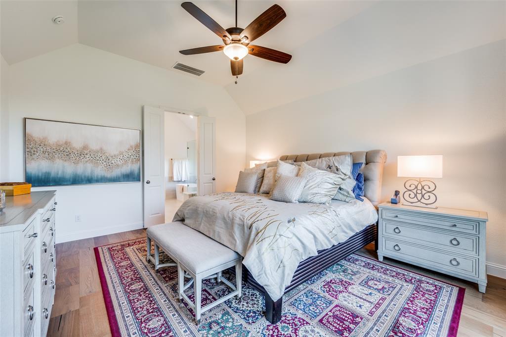 2390 Red Cedar Trail Prosper, TX 75078 - Photo 23 of 40 a bedroom with a bed a lamp and a bookshelf