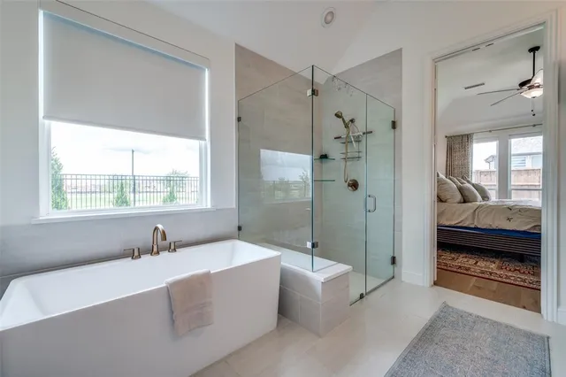 a spacious bathroom with a tub shower and windows