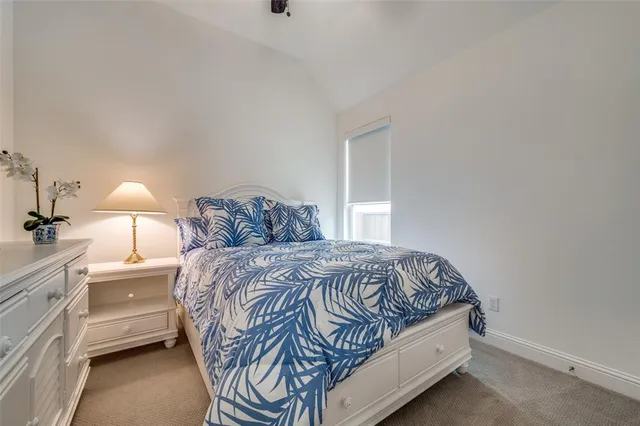 a bedroom with a bed and a lamp on the dresser