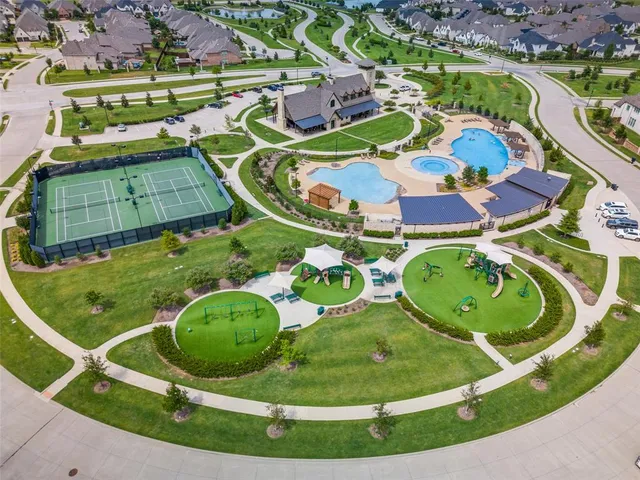 an aerial view of a swimming pool with a yard and plants