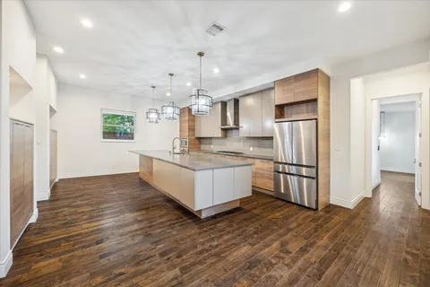 a large white kitchen with wooden floor and a sink
