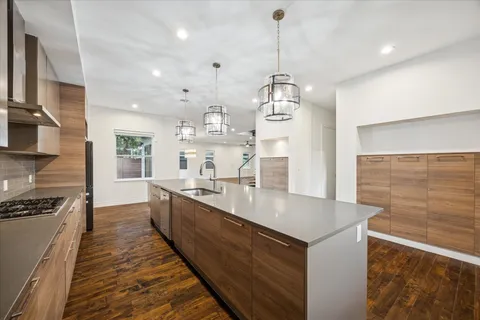 a large kitchen with kitchen island a stove a sink a refrigerator and windows