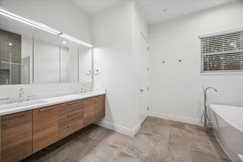 a bathroom with double vanity and a mirror