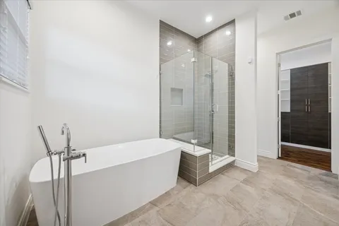 a spacious bathroom with a bathtub and shower