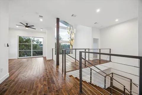 a view of staircase with wooden floor and fan