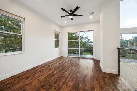 a view of a livingroom with wooden floor and a ceiling fan