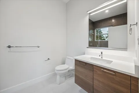 a bathroom with a sink a toilet and a mirror