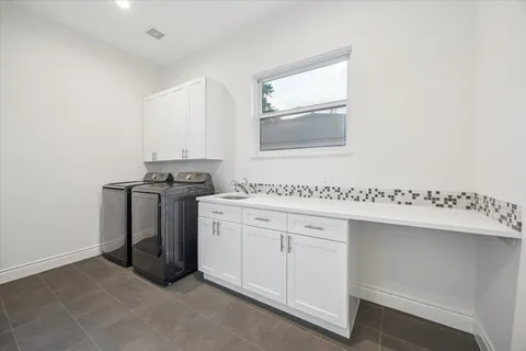a utility room with cabinets washer and dryer