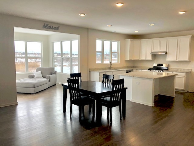 4341 Rudyard Kipling Road Elgin, IL 60124 - Photo 10 of 30 a kitchen with stainless steel appliances granite countertop a dining table chairs stove a refrigerator and cabinets