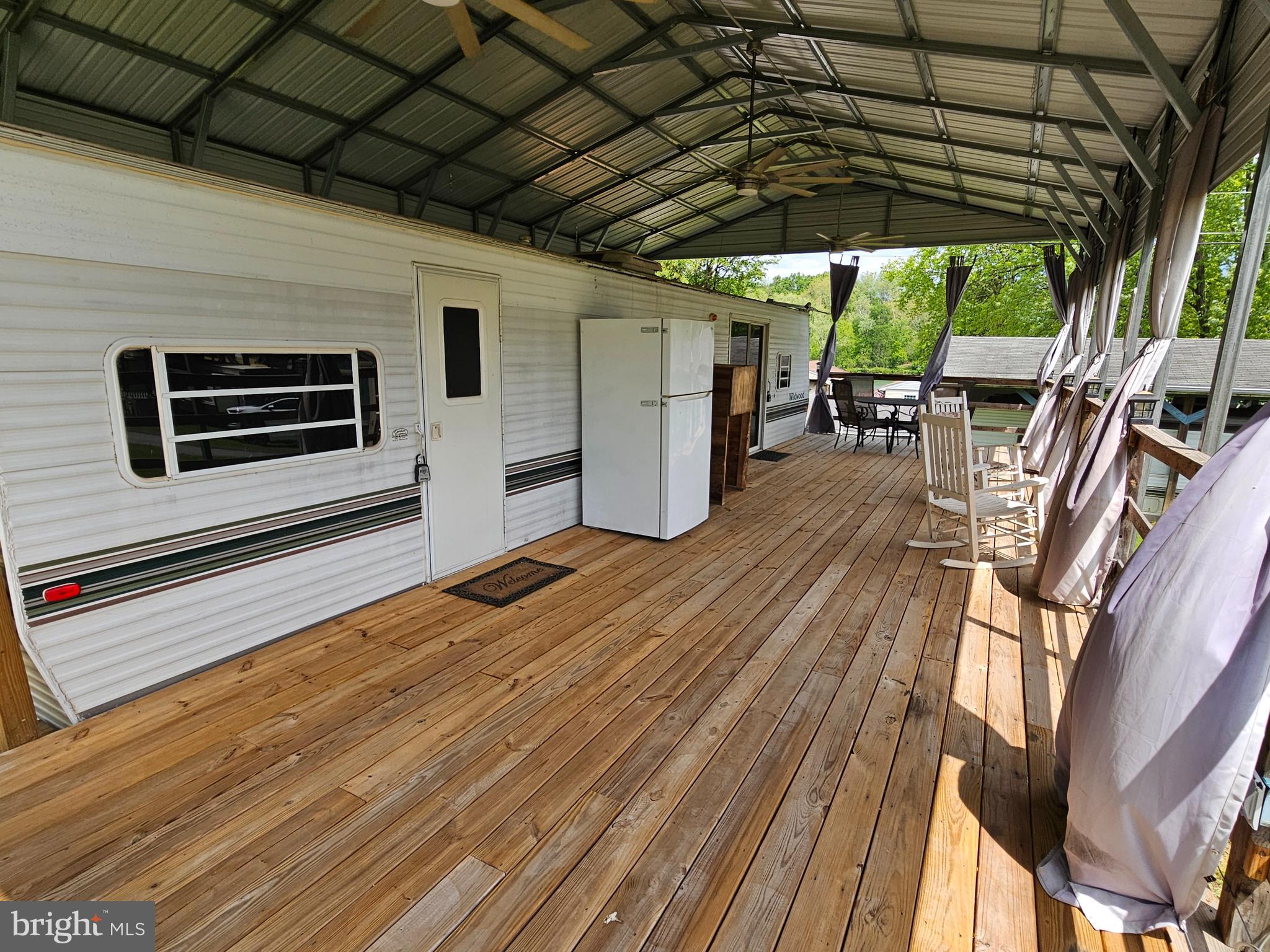 21 Campfire Boulevard Falling Waters, WV 25419 - Photo 8 of 30 a view of a patio with table and chairs under an umbrella with wooden floor