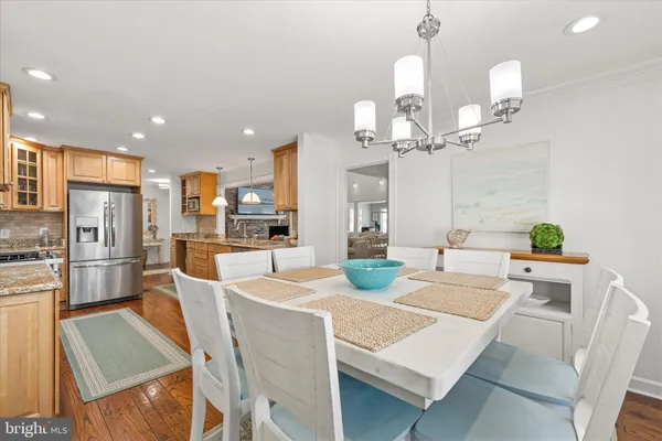 a kitchen with stainless steel appliances kitchen island granite countertop a stove a sink a dining table and chairs