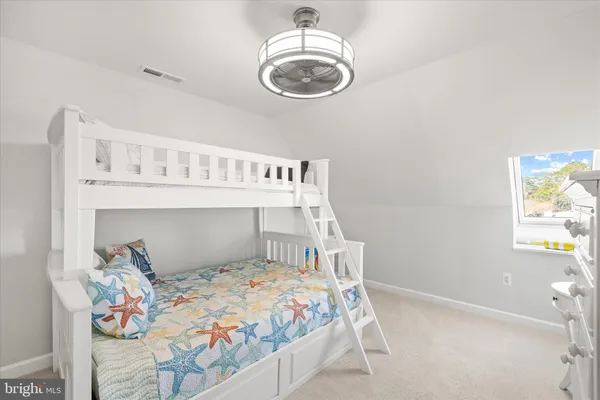 a bedroom with a bed a chandelier and a dresser