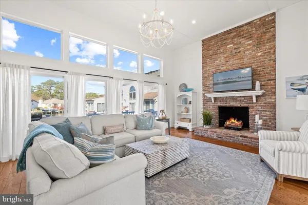 a living room with furniture a fireplace and a chandelier