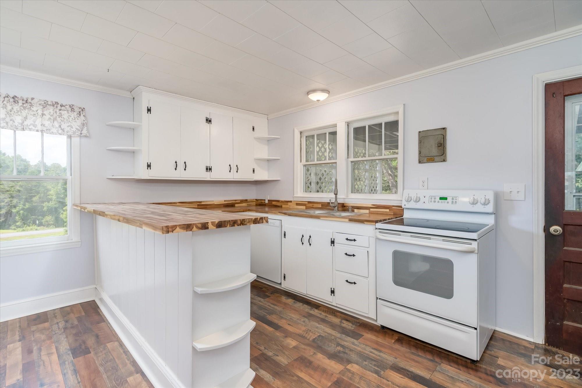 2540 Maple Creek Road Rutherfordton, NC 28139 - Photo 14 of 48 a kitchen with stainless steel appliances white cabinets and wooden floor