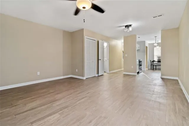 wooden floor in an empty room with a ceiling fan
