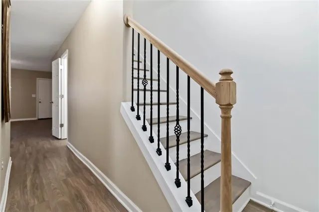 a view of staircase with wooden floor and white walls