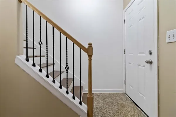a view of staircase with railing and white walls