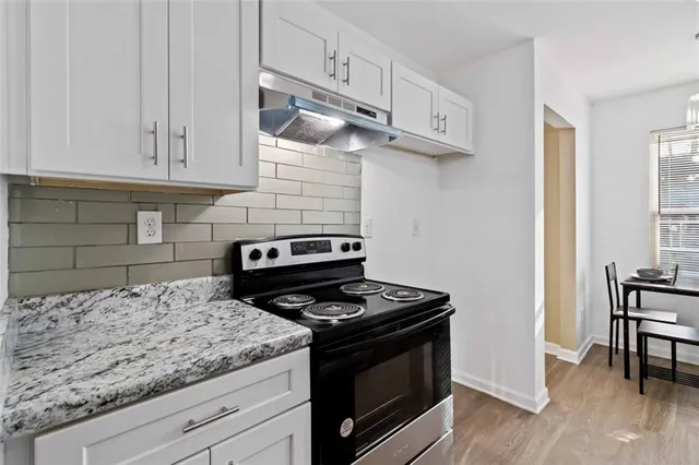a kitchen with granite countertop stainless steel appliances and wooden cabinets