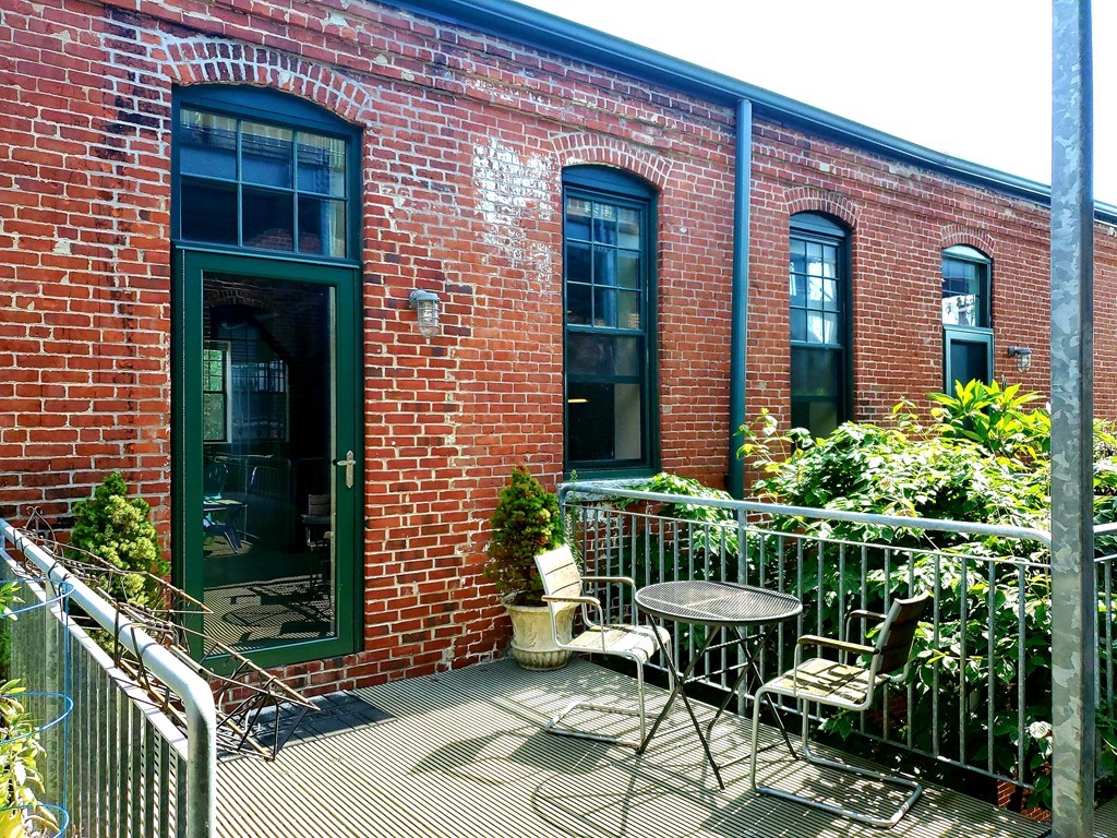 60 Dudley Street, Unit 22 Chelsea, MA 02150 - Photo 1 of 15 a view of a brick house with a chair and table in a patio